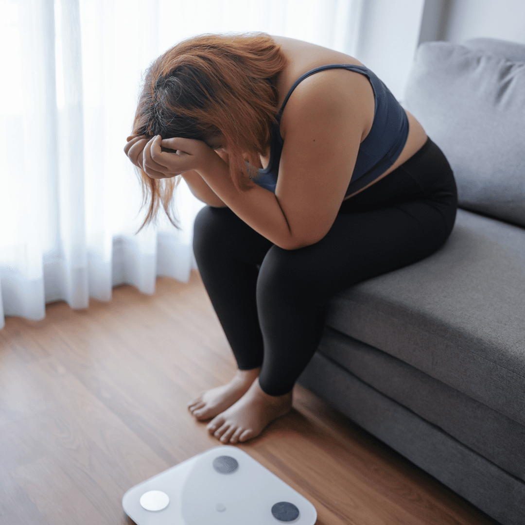 une femme en surpoids est découragée. Une approche énergétique avec le Reiki, le Chamanisme, l'EFT et la réflexologie palmaire peut l'aider.